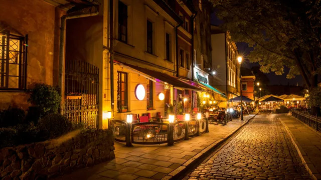 Cozy street café lights in Kazimierz, cobblestones, evening atmosphere.