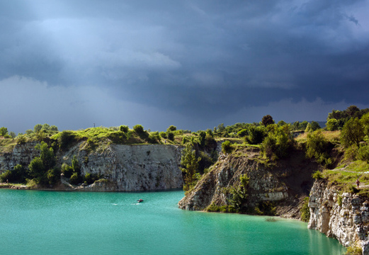Turquoise water, limestone cliffs, people walking along the top trail.